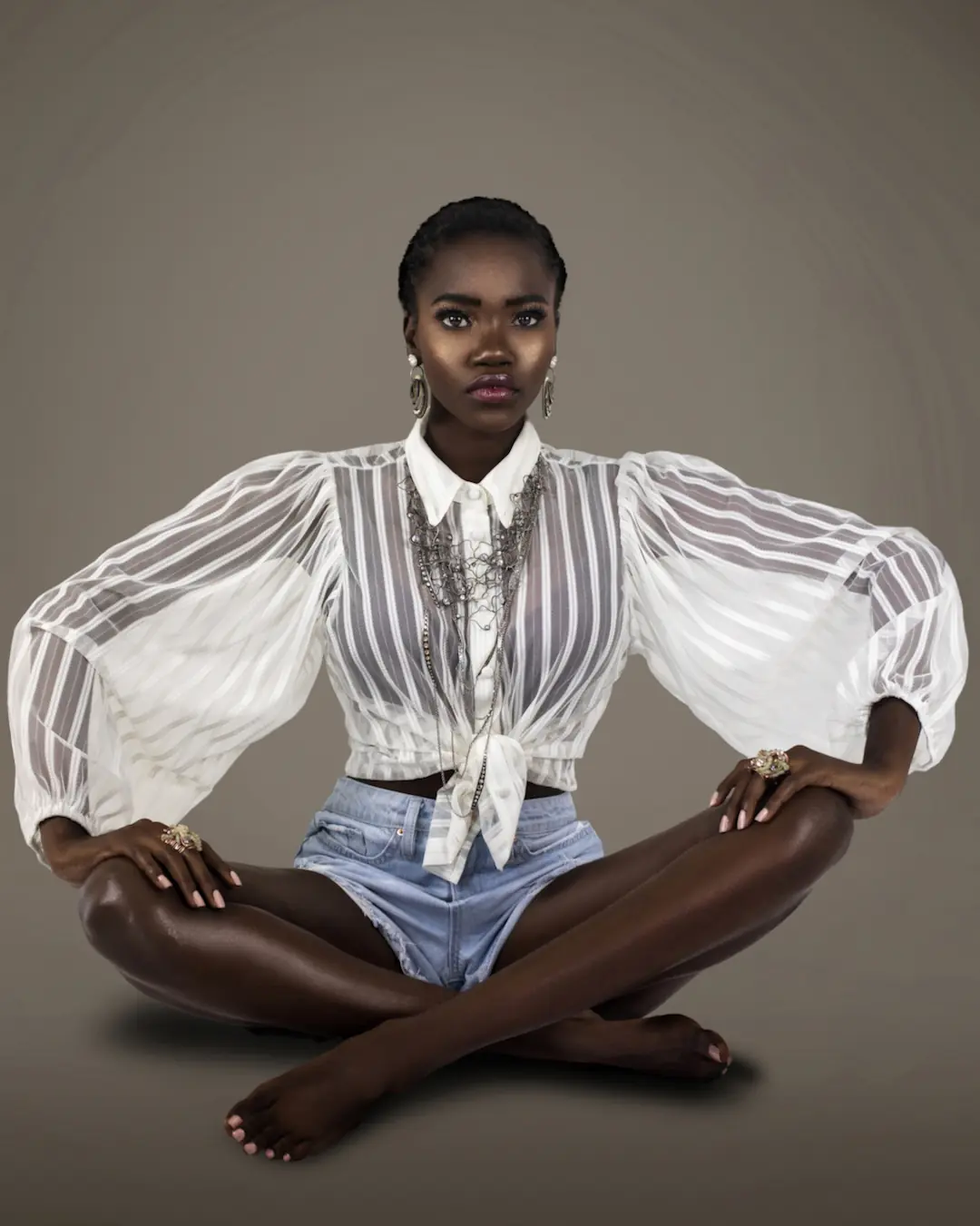 Clean & Serene: How Beauty Editorial Creative Direction Turned a Mood Board into a Published Story - Phil Halfmann Beauty editorial photography of Gaelle Augustin seated in a sheer white blouse with layered jewelry