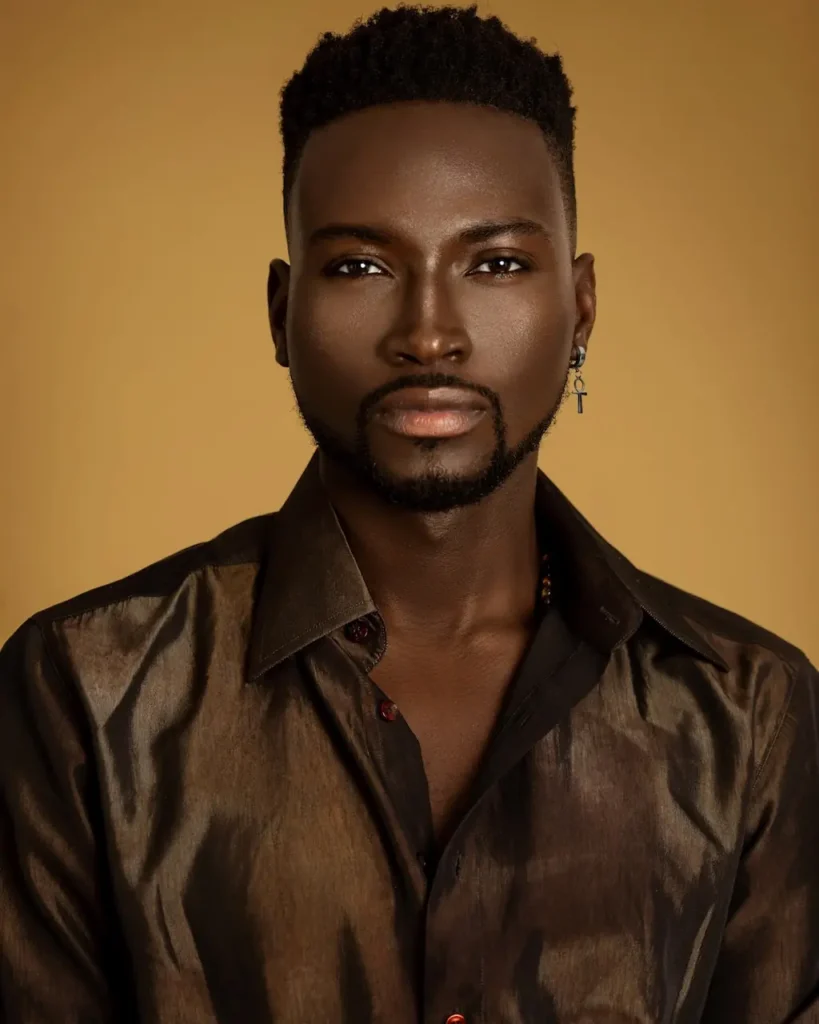 Male model photographed against a warm gold background for complementary campaign portrait coverage