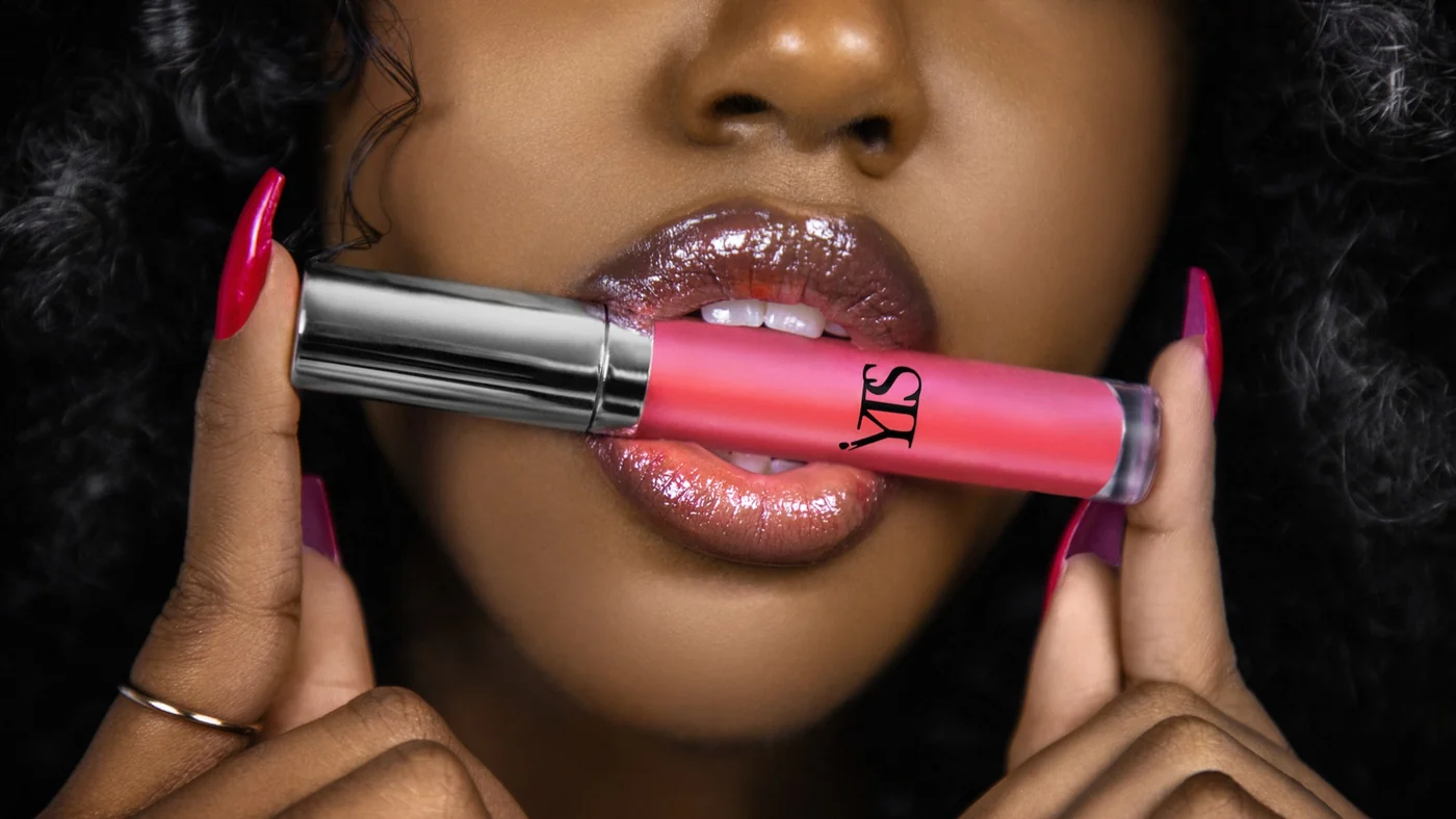 Close-up beauty product photograph of a model holding Your True Shade pink lip gloss