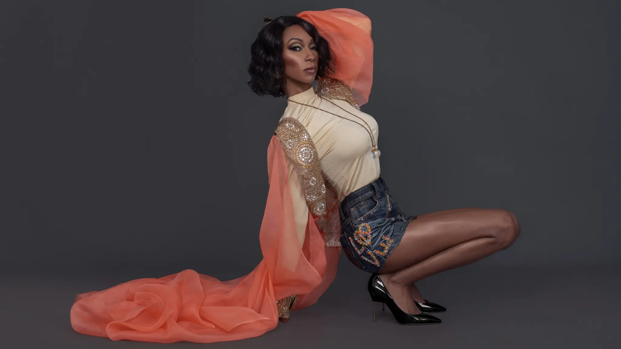 Tanya Marie content infrastructure campaign with a model wearing coral draping and an embellished denim skirt