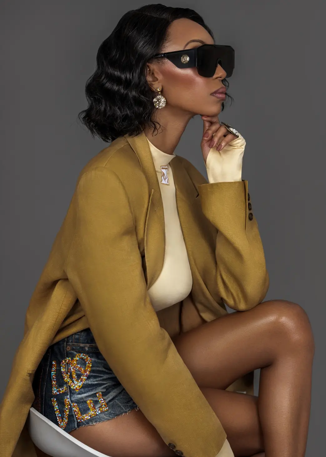 Mustard tailoring and eyewear portrait showing accessory detail within Tanya Marie’s content infrastructure