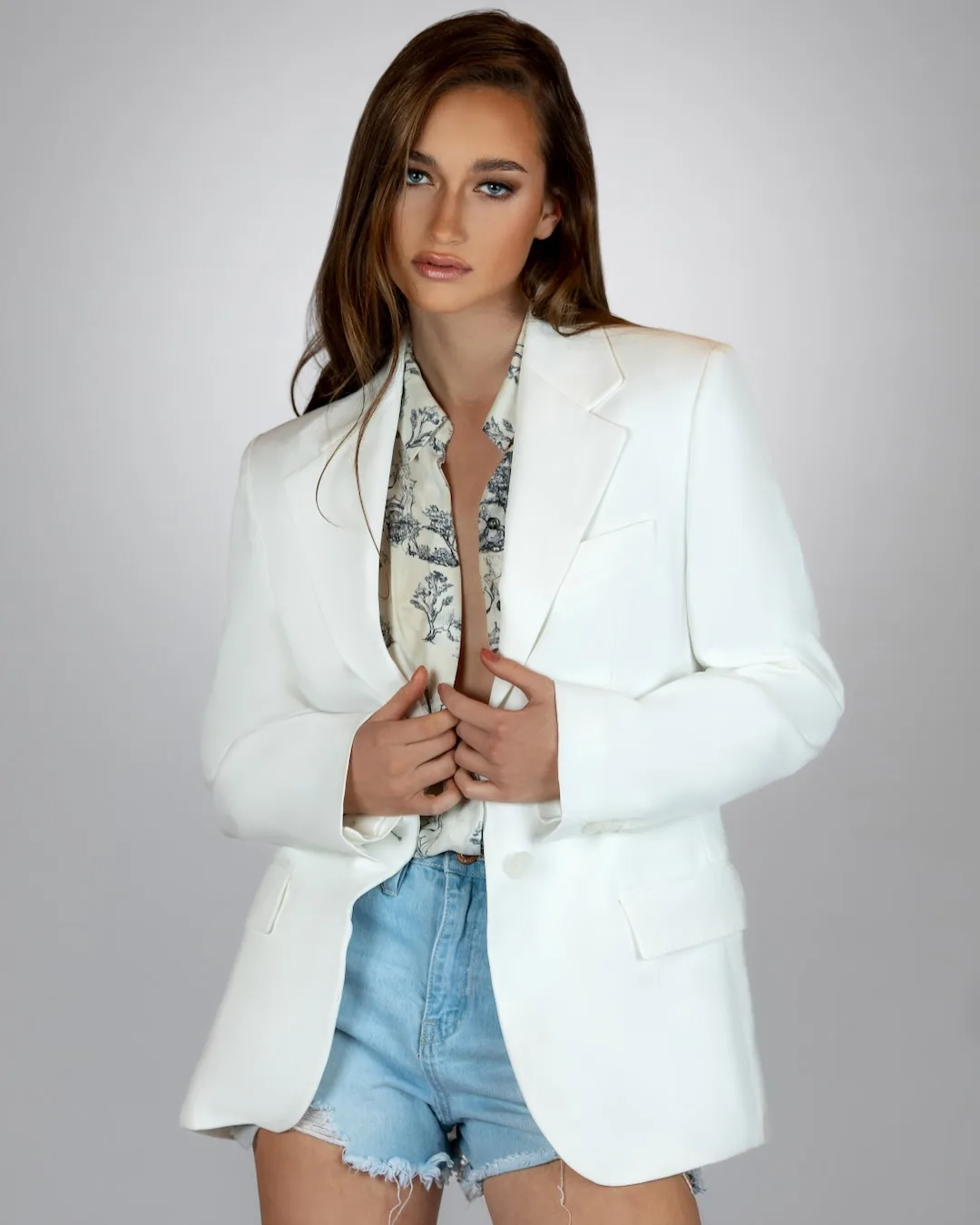 Model in a white Mango blazer styled for a clean multi-brand fashion editorial.