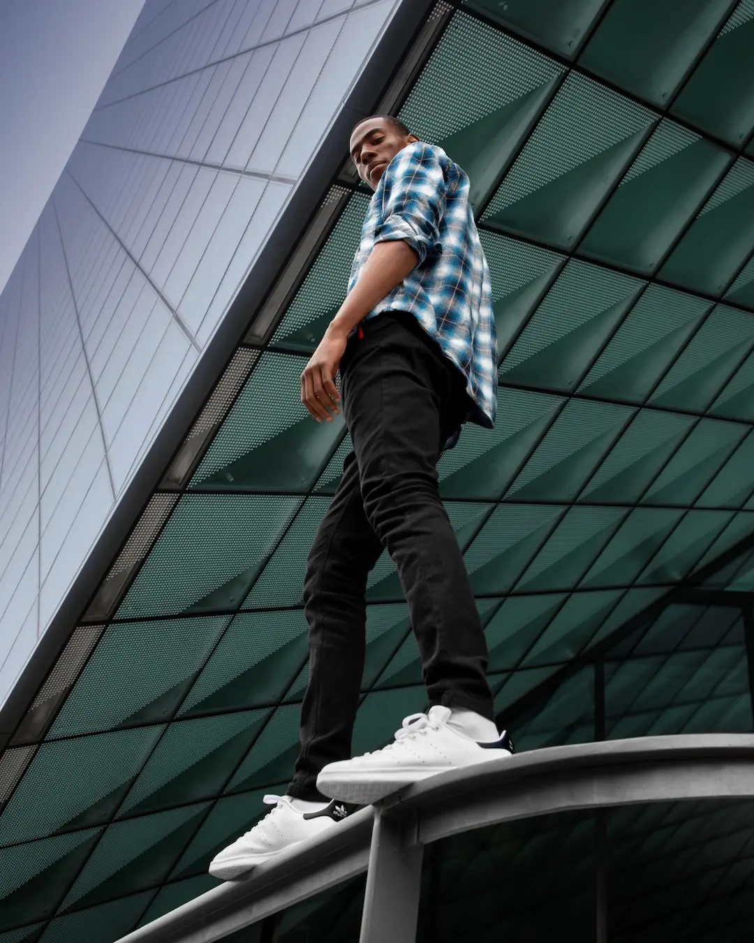 Male athlete photographed from a low angle against modern Berlin architecture