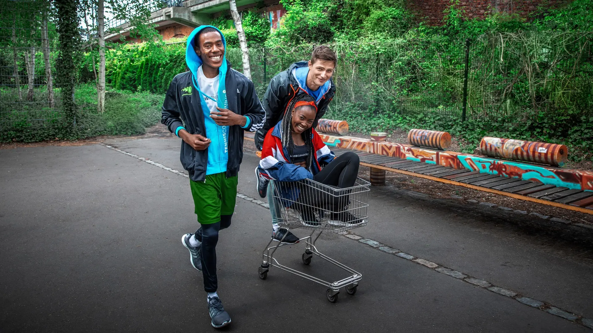 Athletes running with a shopping cart near a Berlin basketball court