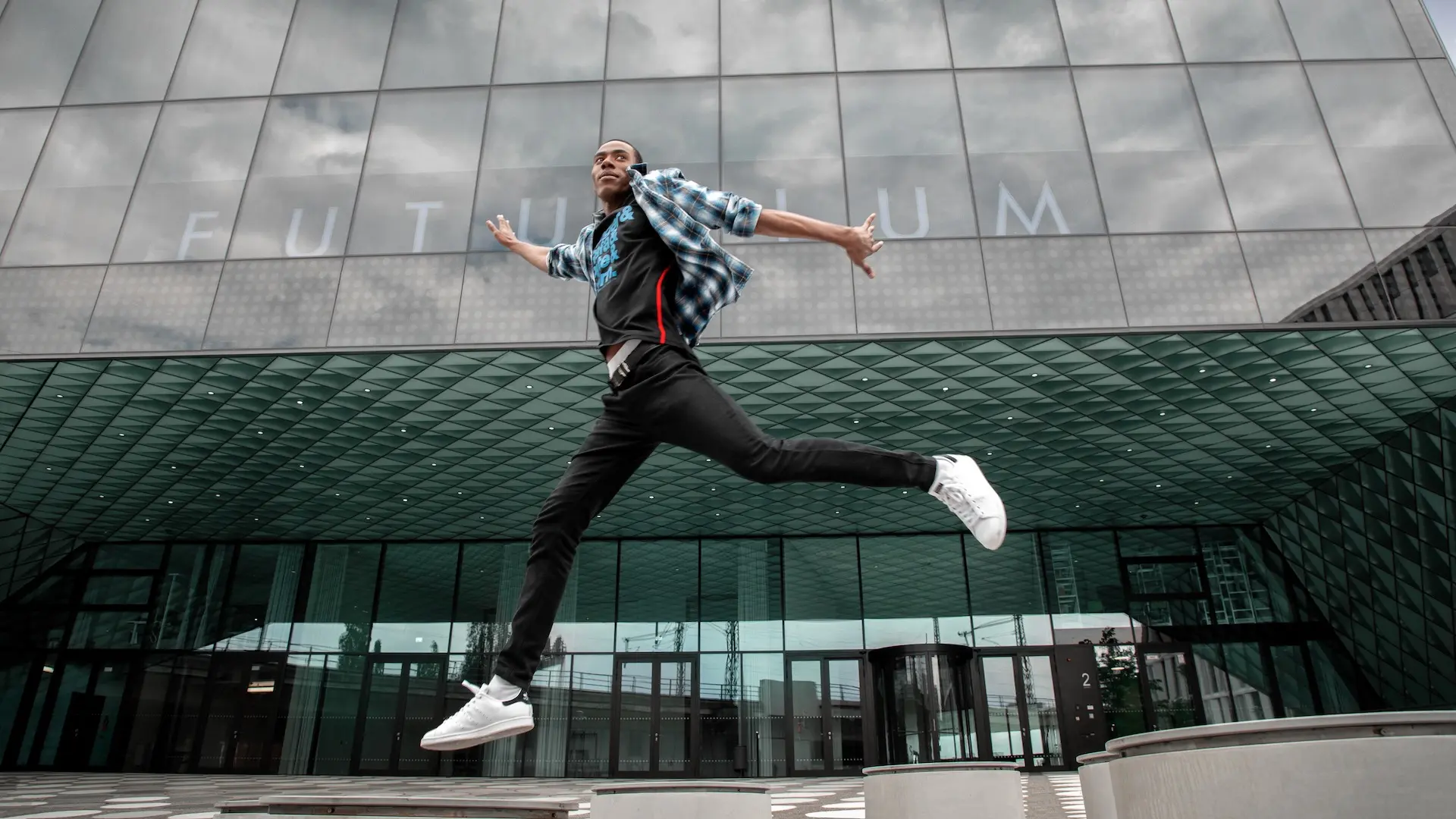 Runner photographed from a low angle against modern Berlin architecture
