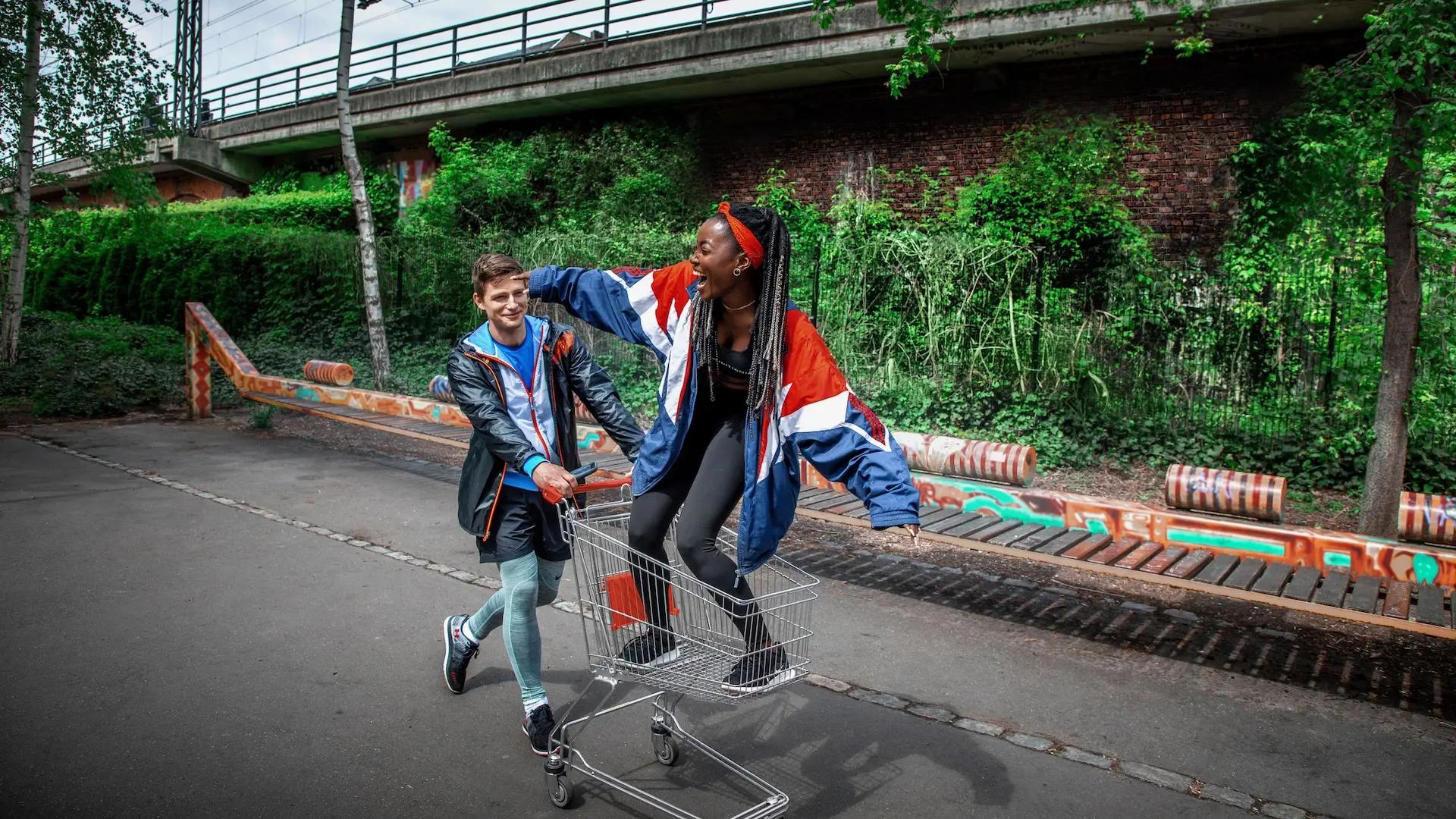 Athletes playing with a shopping cart in an urban Berlin sports setting