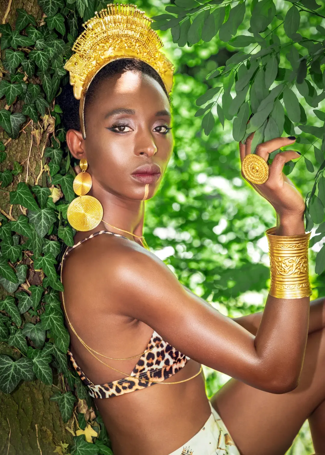 Sculptural Headpieces in Berlin: Building a Cohesive Fashion Editorial Across Six Models - Phil Halfmann Model in a gold headpiece photographed against green foliage in Berlin