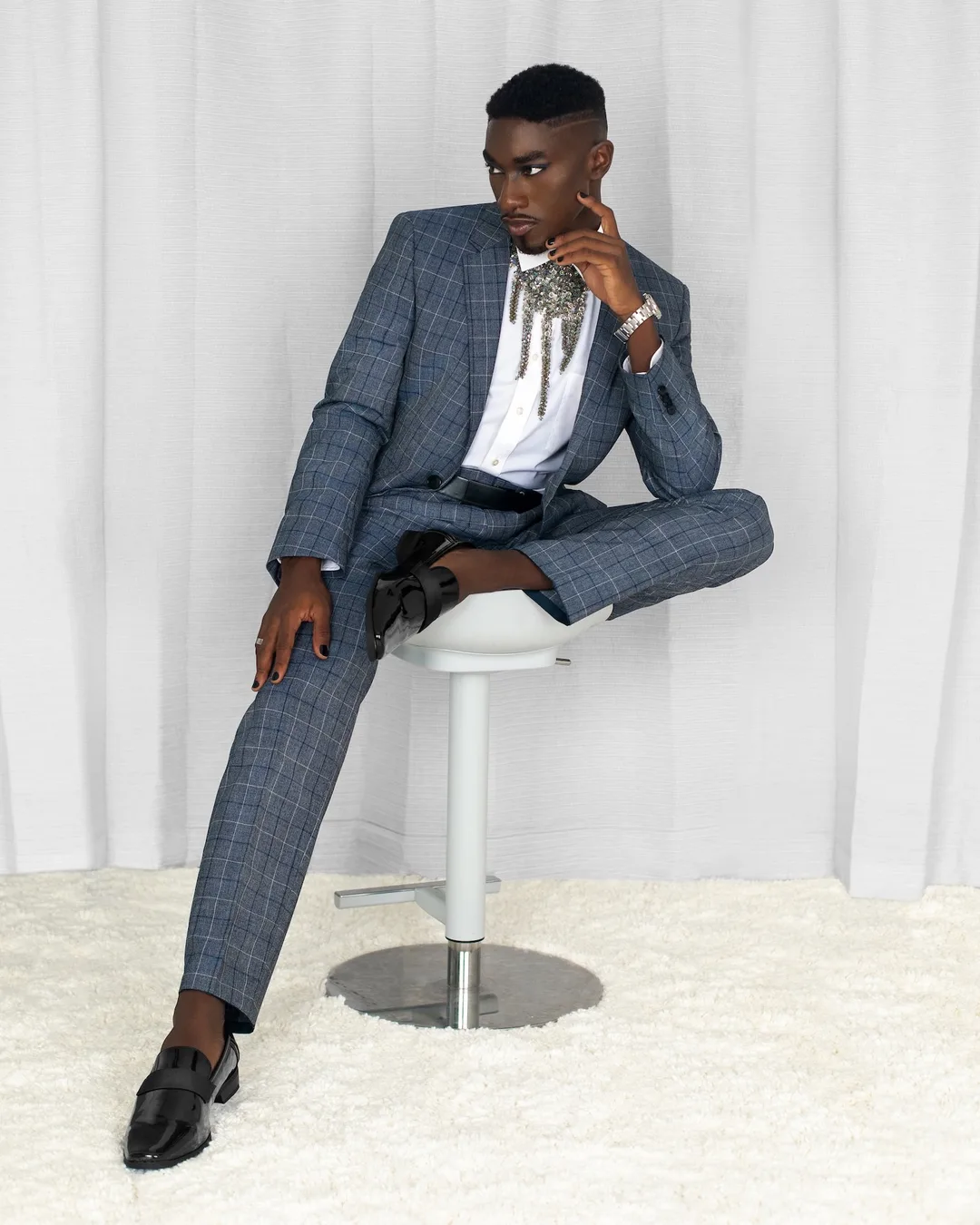 Troy in a blue checked suit photographed from a low angle
