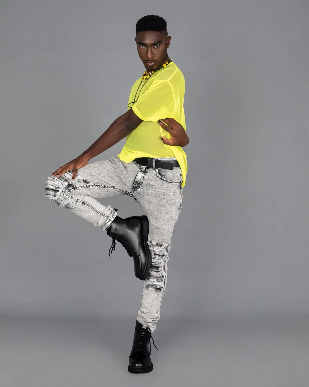 Troy balancing in a bright yellow shirt and distressed jeans