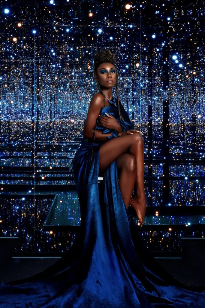 Ann-neika wearing a sculptural blue dress in the Colour Me Beautiful music-inspired beauty editorial