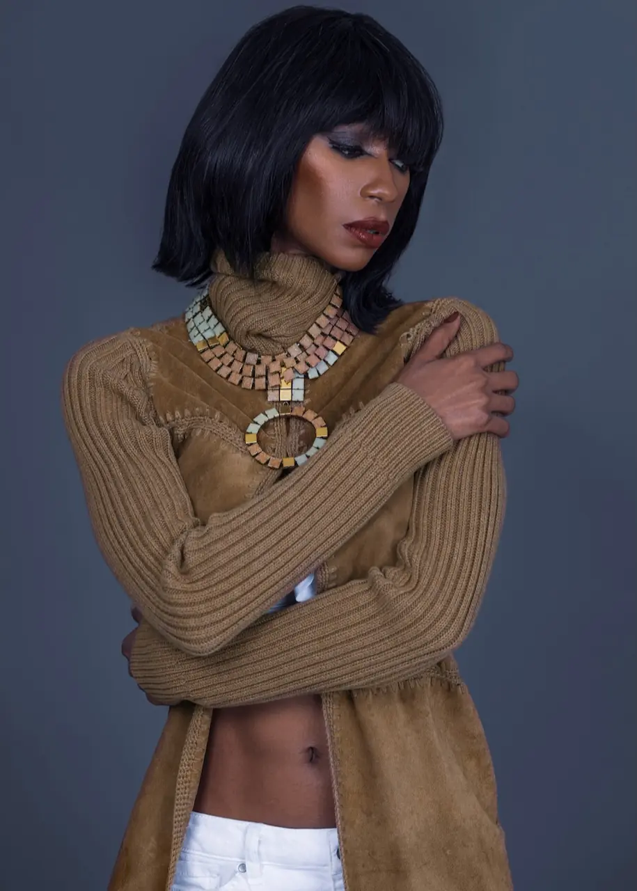 Studio Fashion Editorial Production: Simple Comforts - Phil Halfmann Jovona Logan wearing a brown knit jacket and statement necklace in a studio fashion portrait.