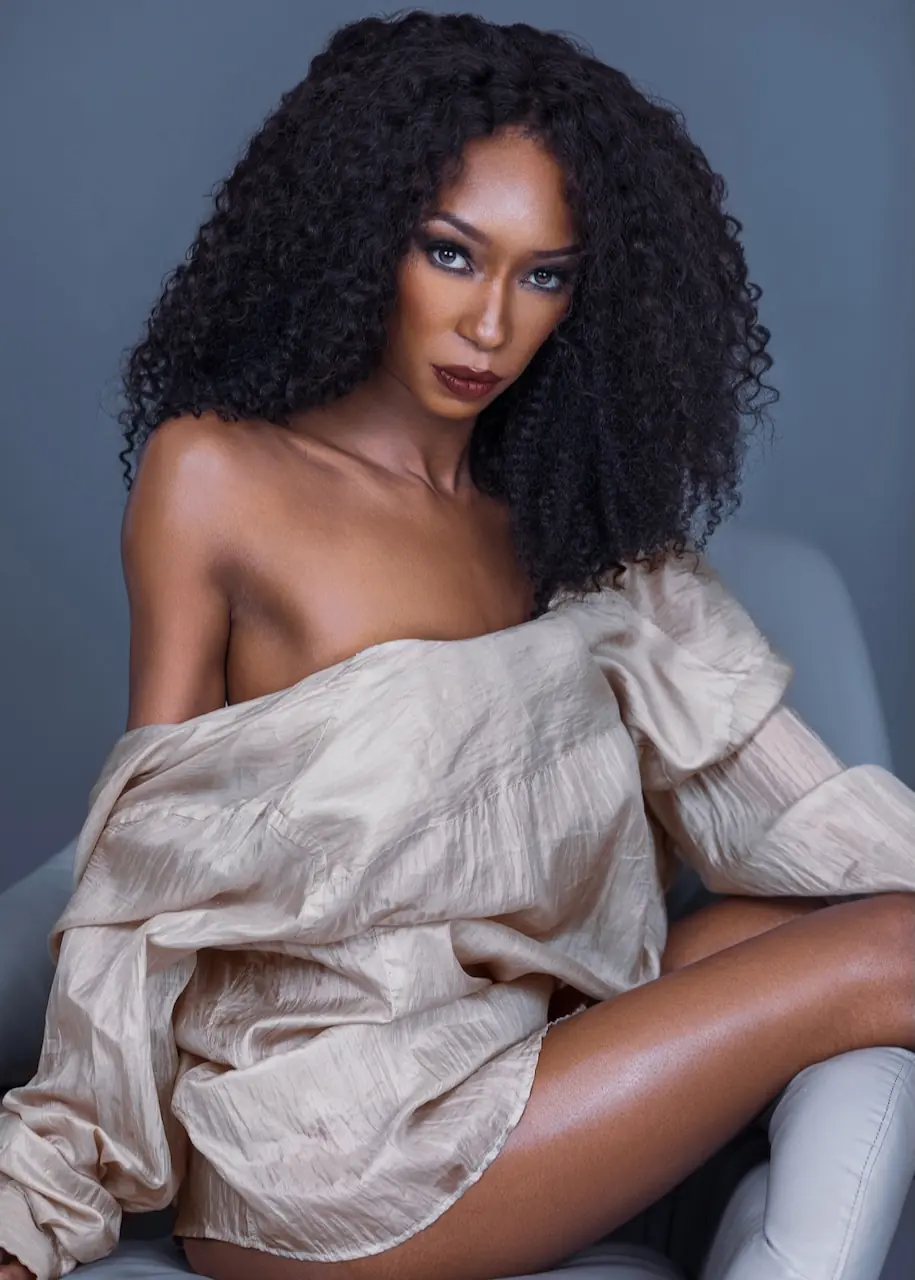 Studio Fashion Editorial Production: Simple Comforts - Phil Halfmann Jovona Logan seated in a neutral off-shoulder shirt for a studio beauty portrait.